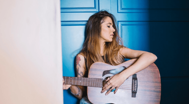 Músico con eléctrica en un escenario con luces tenues