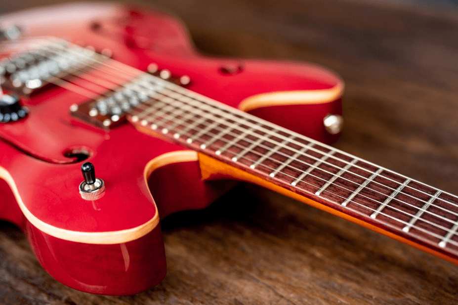 Guitarra eléctrica semihueca roja sobre una superficie de madera