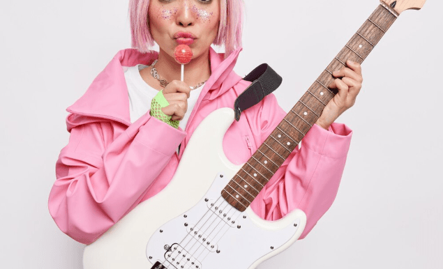 Guitarrista concentrado tocando una eléctrica en interior