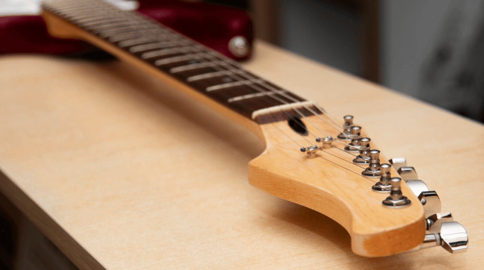 Primer plano del mástil y clavijero de una guitarra acústica