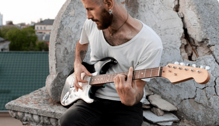 Persona concentrada tocando una guitarra acústica