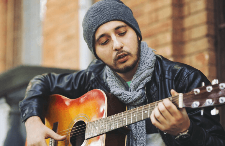 Guitarrista con acústica en un estudio sencillo