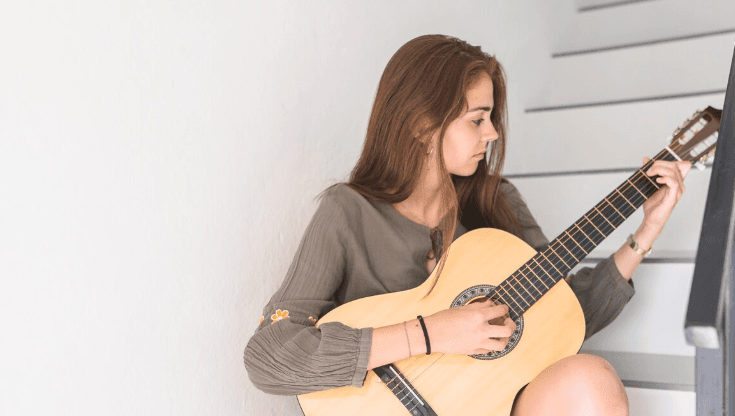 Músico joven con acústica en un ambiente informal